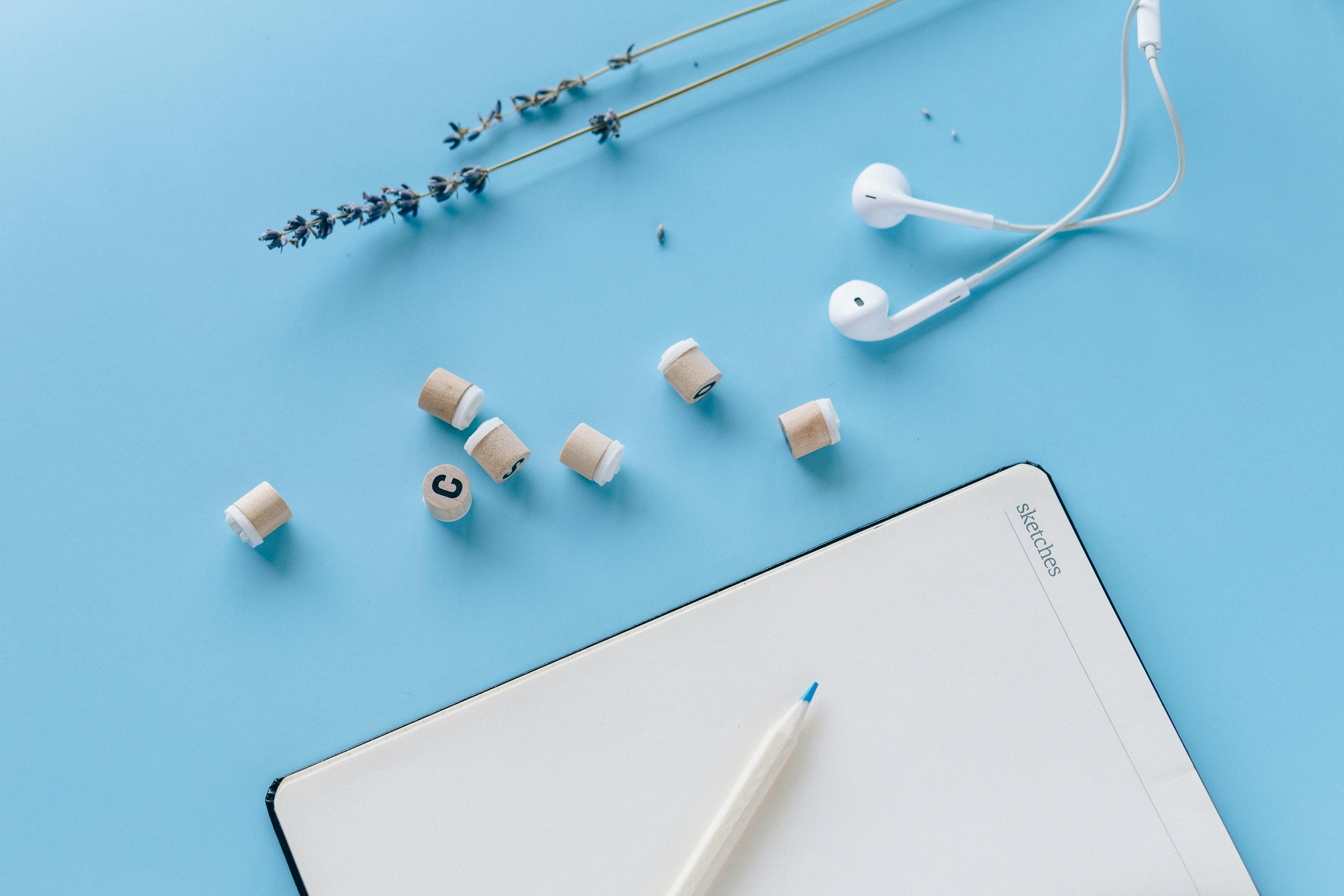 White earbuds and white iPad with a white background